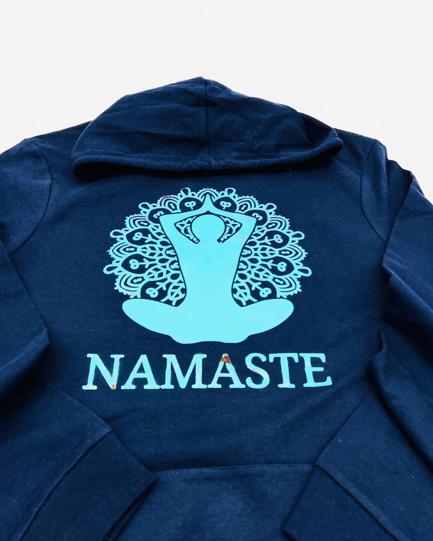 Bild einer Yoga-Position mit Blume des Lebens und der Unterschrift "Namaste" in Hologramm Flexfolie. Je nach Lichteinfall aendert sich die Farbe und erzielt einen 3D-Effekt.