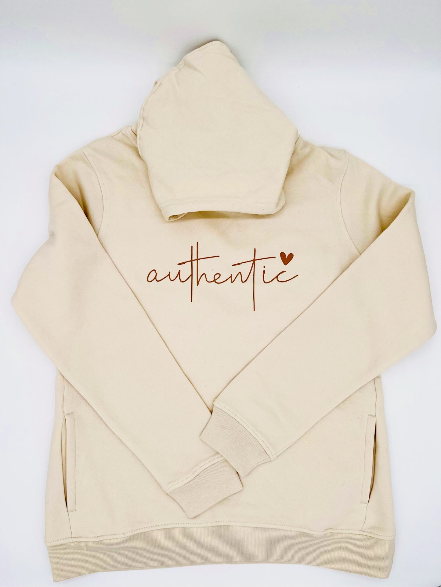 Hoodie in creme farbe. Auf der Brust ist, in einem Brauchton, das Wort "authentic" gedruckt. Ueber dem Buchstaben "c" ist ein Herz abgebildet.