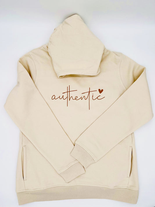Hoodie in creme farbe. Auf der Brust ist, in einem Brauchton,  das Wort "authentic" gedruckt. Ueber dem Buchstaben "c" ist ein Herz abgebildet.